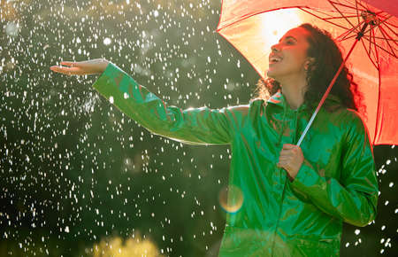 To appreciate the sun youve got to withstand the rain. a beautiful young woman having fun in the rain.の写真素材