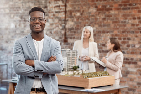 Happy, smiling and confident manager standing with arms crossed while working in office at work. Businessman, ceo or leader looking cheerful, joyful and proud with arms folded at a startup companyの写真素材