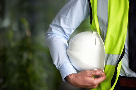 Ready to do some site inspections. Closeup shot of a white construction helmet being held by an unrecognizable male engineer.の写真素材