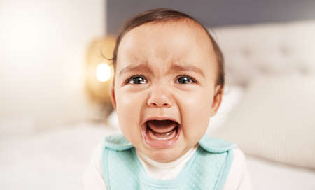 Dont you dare leave me alone. an adorable little girl crying while sitting on a bed.の写真素材