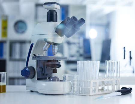 Research made easier by technology. a microscope and goggles on a table in a laboratory.
