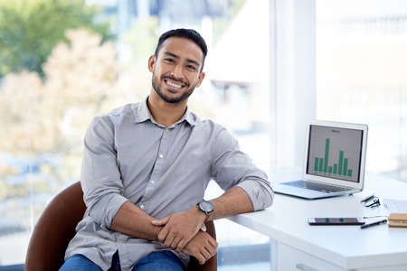 Be tough, be ambitious and know exactly what you want. Portrait of a confident young businessman sitting in an office.の写真素材