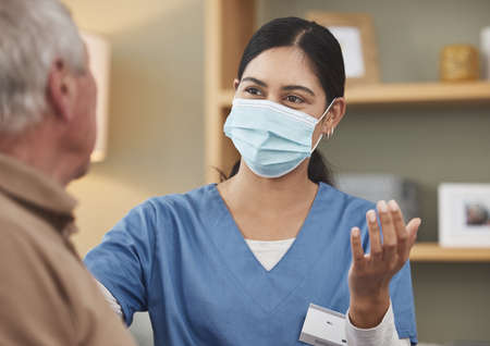 Her number one priority is healthcare. a young female nurse having a checkup with an elderly patient at home.の写真素材