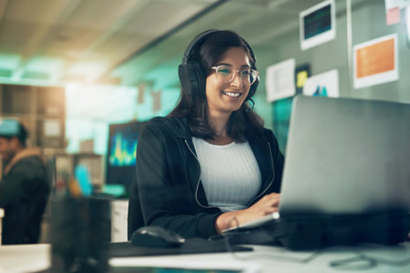 Taking my shot and doing it well. a young woman using a headset in a modern office.の写真素材