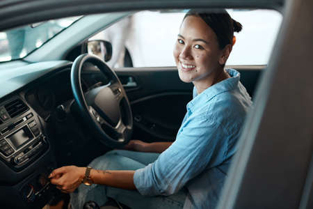 Ill remember this moment forever. a young woman testing out a car she just purchased.