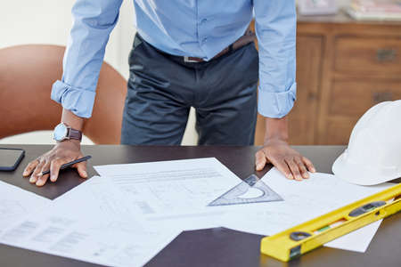 Challenges arent meant to break you but build you. an architect working on paperwork at his desk.の写真素材