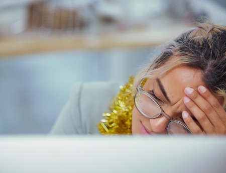 Should have grabbed those painkillers. a young woman suffering from an intense headache at her desk in the office.の写真素材