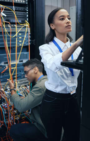 The coding team you need. two young computer programmers working together in a server room.
