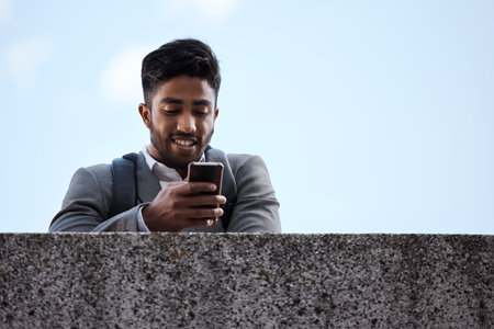Always ready to start work at any time. a young businessman using a phone in the city.の写真素材