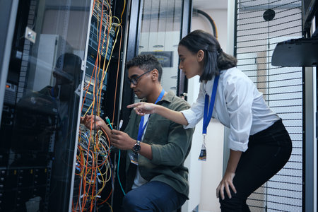An extra set of eyes always helps. two young computer programmers working together in a server room.