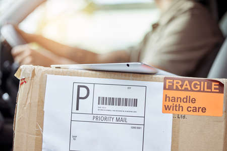 Another shipment ready to be delivered. a delivery man driving to drop off a package.の写真素材