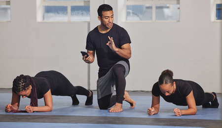 One minute feels like an hour when youre planking. two young women exercising with a trainer at the...