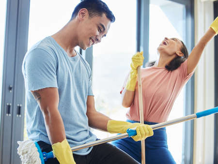 Remember to have fun. a couple taking a break from mopping their house to dance around.の写真素材