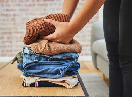 Keeping my closet clean and neat. a woman folding a load of laundry.
