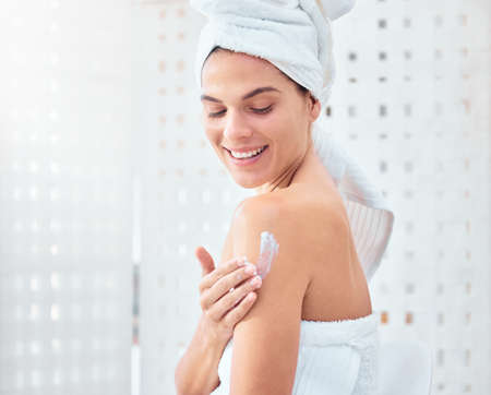 Soft skin brings me joy. a woman applying moisturiser to her arms and shoulders.