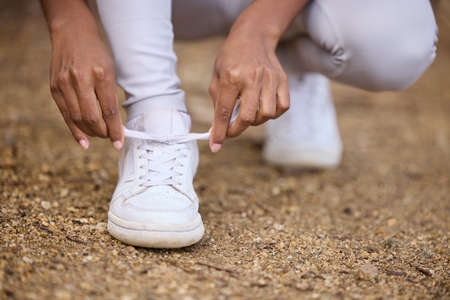 Lets get this morning run started. Closeup shot of an unrecognisable woman tying her shoelaces while...
