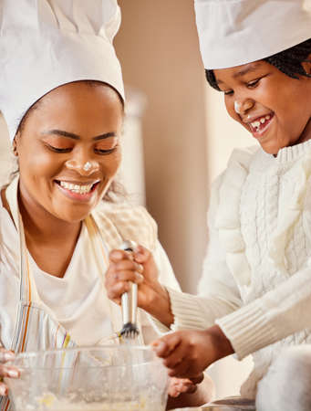 Dont forget to add a little love. a mother and her daughter baking in the kitchen at home.の写真素材