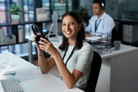 We dont believe in impossible. Portrait of a young woman using a headset and computer in a modern...