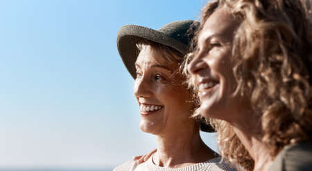 Taking in the views. two attractive mature women standing on the beach.の写真素材