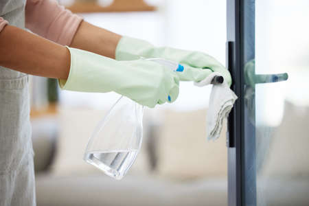 Cant forget to sanitise the door handles. an unrecognizable person cleaning a door handle at home.の写真素材