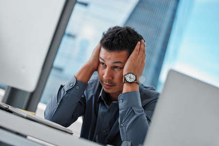 Well thats my job gone. a handsome young businessman sitting alone in the office and feeling...