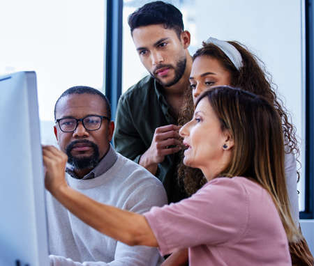 Making sense of their innovative plans. a group of businesspeople working together on a computer in an office.の写真素材