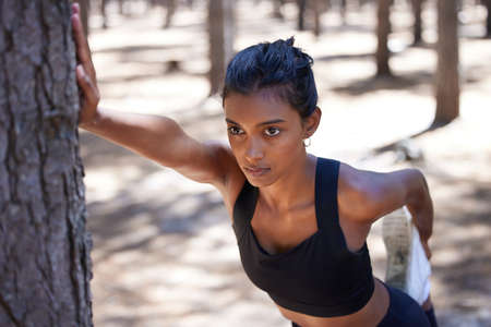 My legs arent going to know what hit them. an attractive young woman standing and stretching before her workout outdoors.の写真素材