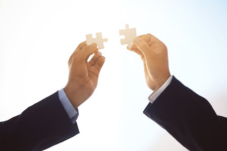 A boundary living so profoundly. two unrecognizable businessmen completing a puzzle.の写真素材