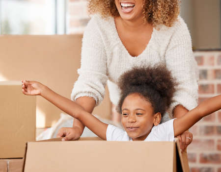 Every day I become a bit more like my mother. a mother pushing her daughter in a box at home.の写真素材