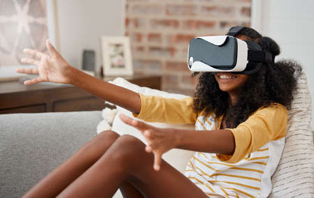 Who needs friends. a young girl playing with a vr headset at home.