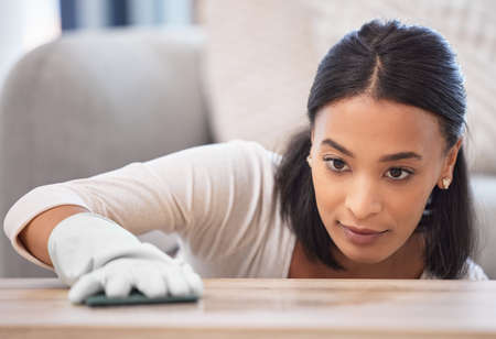 Squeaky clean surfaces. a young woman cleaning a surface at home.
