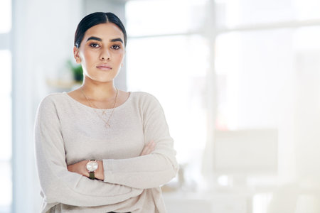 Success is a difficult but good journey. Portrait of a confident young businesswoman standing in an...