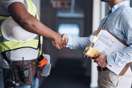 Well start the renovations then. two unrecognizable architects standing together and shaking hands after a discussion about the room before they renovate.の写真素材