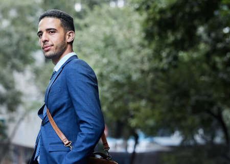 Business savvy. a handsome young businessman on his morning commute into work.の写真素材