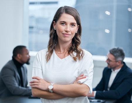 Believing in yourself can enhance your resilience. Portrait of a confident young businesswoman standing in an office with her colleagues in the background.の写真素材