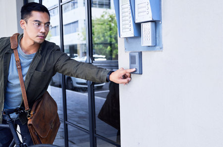 Buzzing my buddy. a young man pressing a button outside of a building.