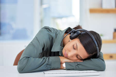 Just a little rest for my eyes. an exhausted businesswoman taking a nap at her desk.