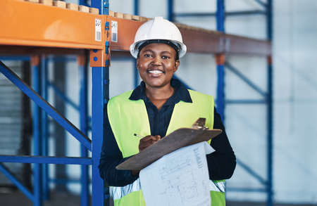 Leading by example for other women out there. an attractive young contractor standing in the warehouse and holding a clipboard.の写真素材