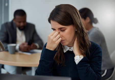 I need a break. a young businesswoman experiencing a headache while at work.