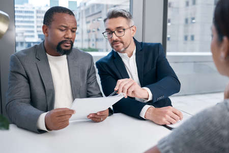 Its listed right there. a group of businesspeople having a meeting in an office.の写真素材