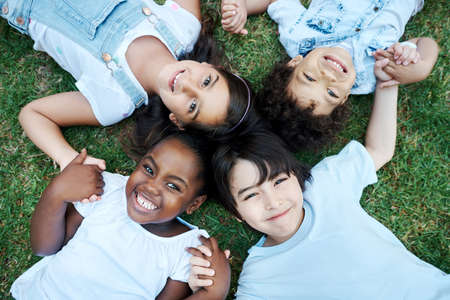 Were all after one thing- Fun. four adorable kids lying together on the lawn.