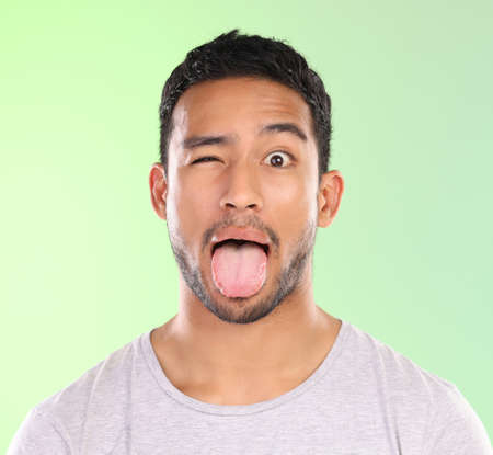 A little quirky. Cropped portrait of a handsome young man making a face against a green background...