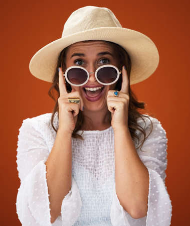 In a sun-shinning kinda mood. Studio shot of a stylish young woman posing against a brown background.の写真素材