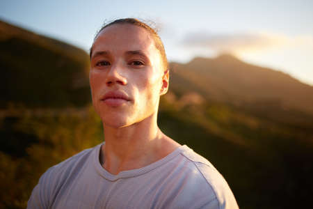 Always get your workouts in early. a young taking a breather during his outdoor training.の写真素材