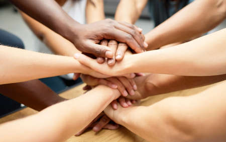 Were stronger as a team. a diverse team of staff piling their hands together.の写真素材