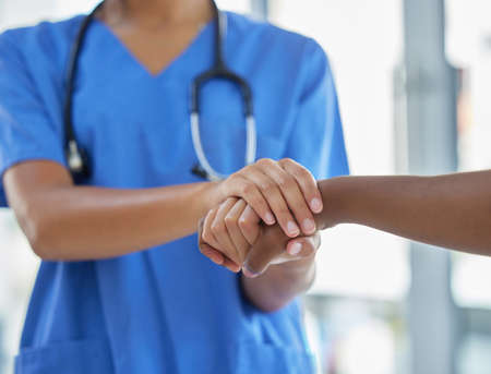 Trusted care for when you need someone to be there. an unrecognisable doctor holding hands with her patient during a consultation.の写真素材