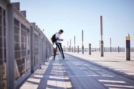 Dont text and cycle. a young man posing in a parking lot on a sunny day.の写真素材