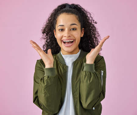 Excited in as understatement. an attractive young woman standing alone against a pink background in the studio and looking surprised.の写真素材