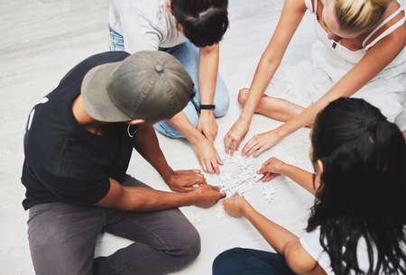 Together well solve this. a group of people solving a puzzle together.の写真素材