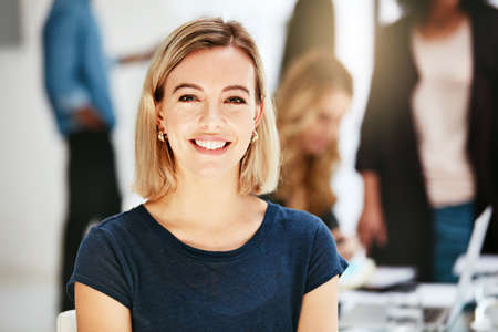 Happy, smiling and confident business woman sitting in a modern office, workspace or workplace....